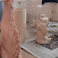 Mehrere ungebrannte Tonobjekte auf Zeitungspapier 