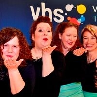 Vier Frauen, die mit Hilfe der Geb&auml;rdensprache kommunizieren vor blauem Hintergrund mit wei&szlig;en vhs-Logo