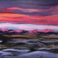 Landschaft mit Bergen im Hintergrund und farbigem Himmel bei Sonnenuntergang